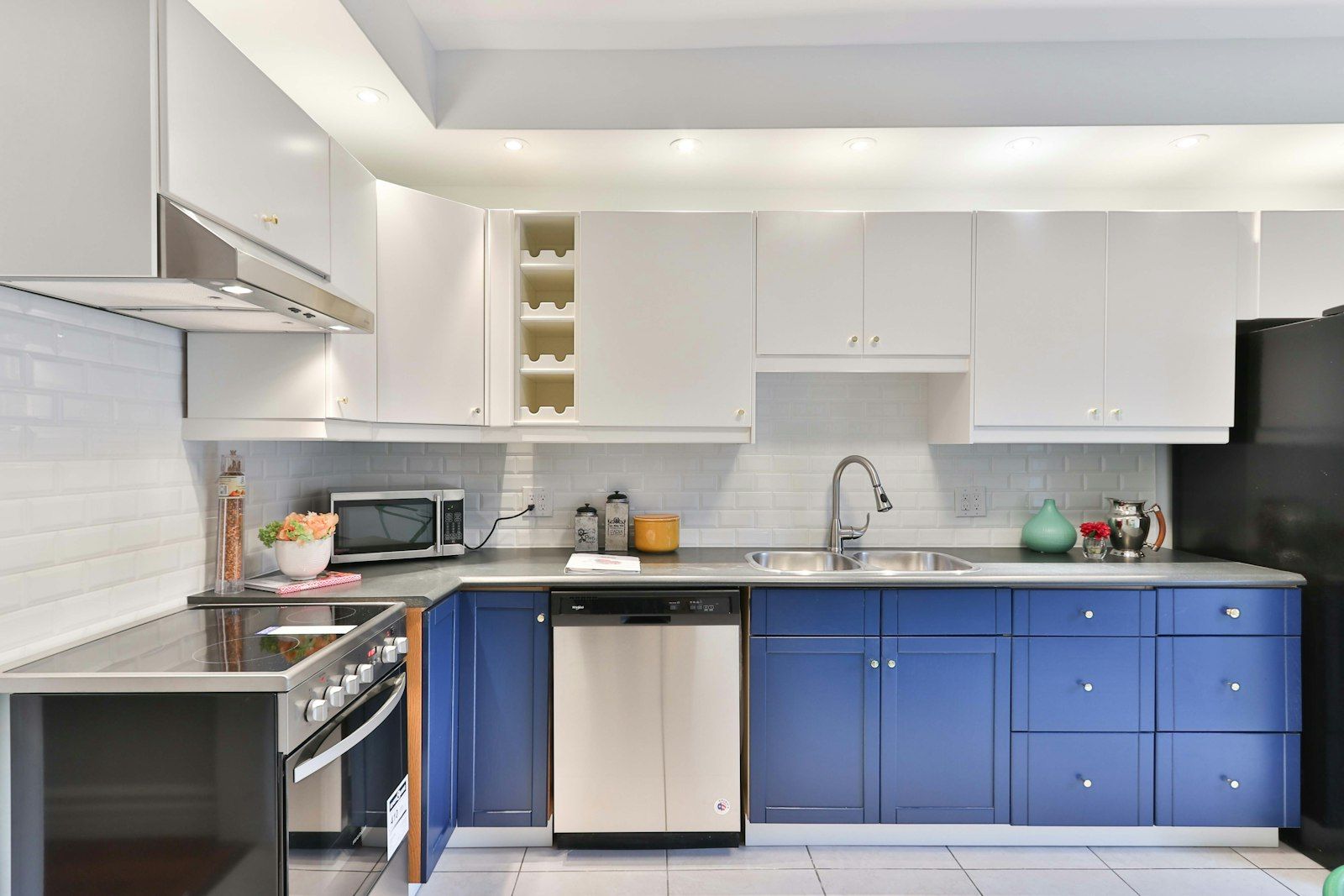 Kitchen with white upper cabinets and blue painted lower cabinets